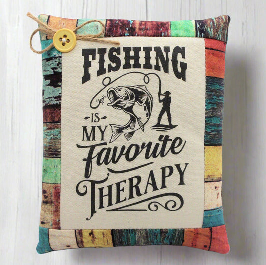 Decorative pillow tuck with fishing-themed text and graphics on a wooden background