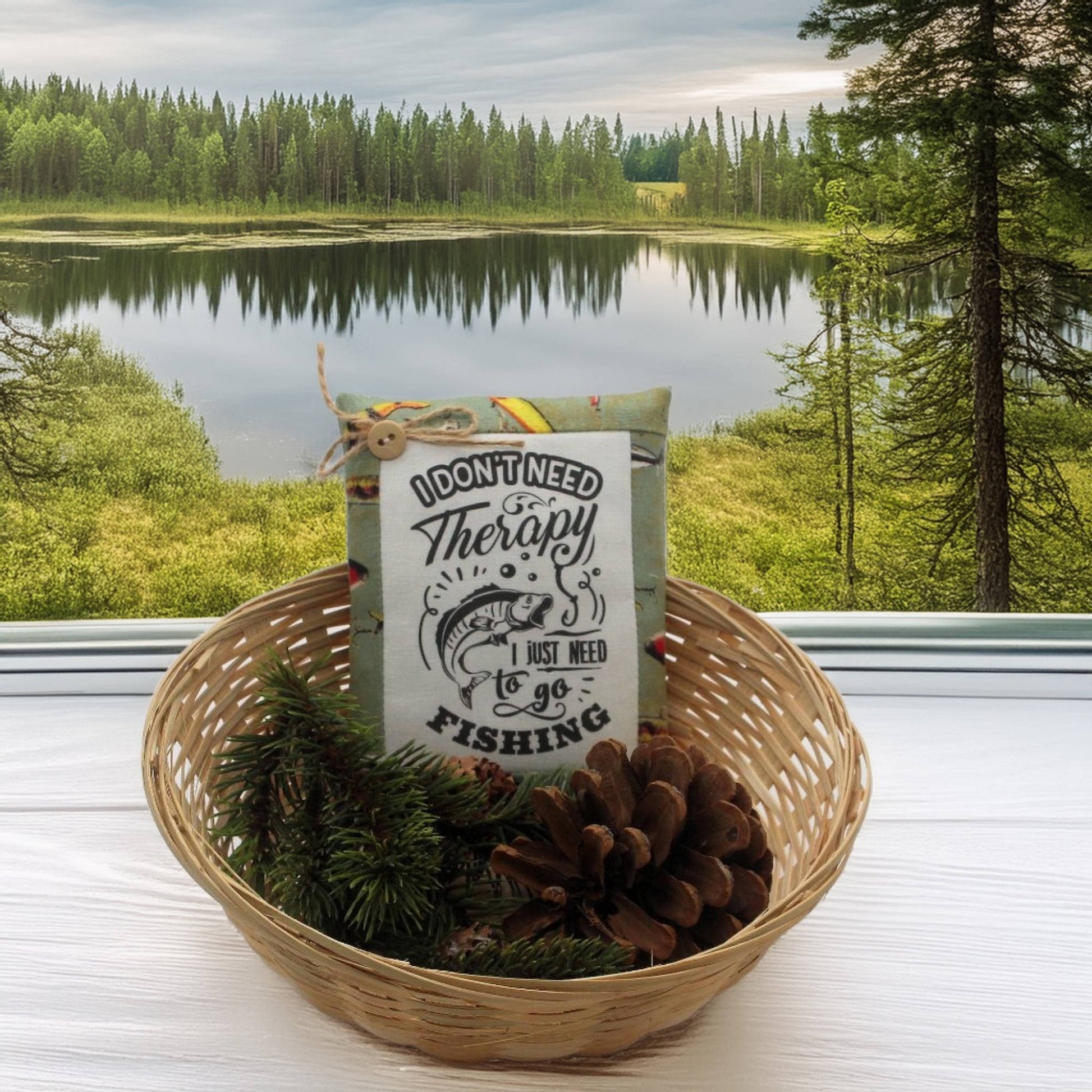 Basket with a sign and fishing-themed items against a scenic lake and forest background