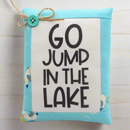 Fabric mini pillow bowl filler with 'GO JUMP IN THE LAKE' text on a light blue border.