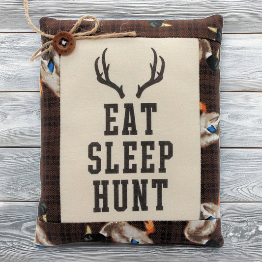 Pillow tuck with 'Eat Sleep Hunt' text and deer antlers on a wooden background