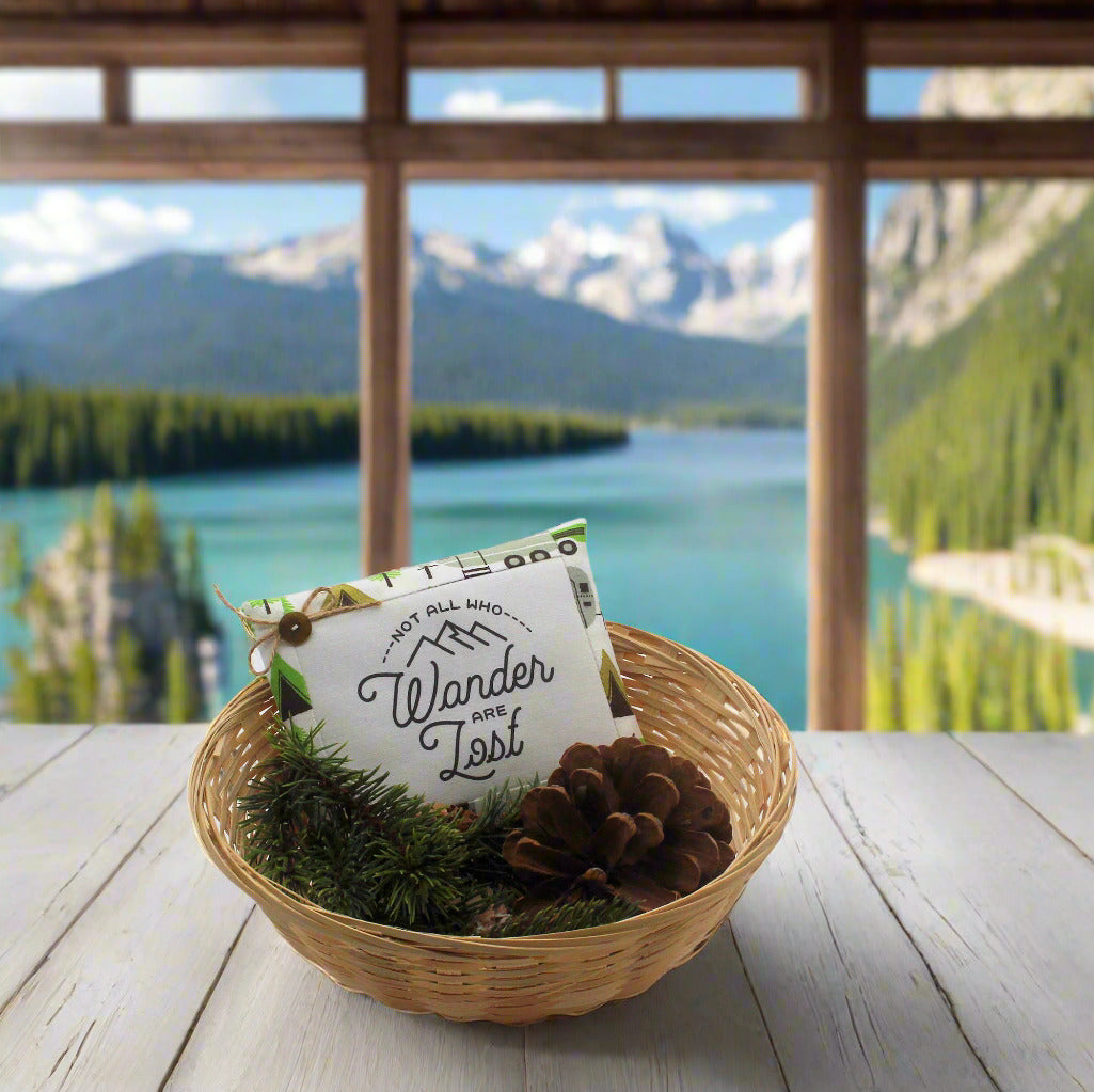 Bowl with decorative elements on a wooden table in front of a scenic mountain and lake view.