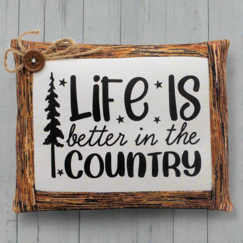 Wooden mini pillow bowl filler sign with 'Life is better in the country' text on a wooden background