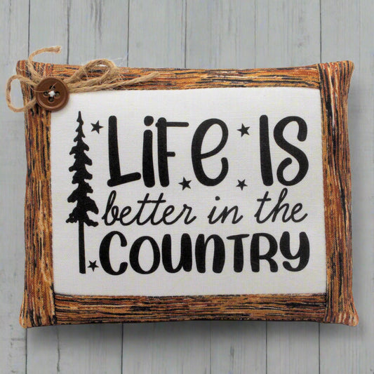 Wooden mini pillow bowl filler sign with 'Life is better in the country' text on a wooden background