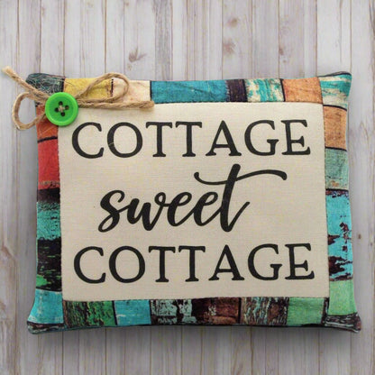 Decorative pillow tuck with 'Cottage sweet Cottage' text on a wooden background