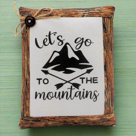 Decorative mini pillow bowl filler with mountain design and text 'Let's go to the mountains' on a green background.