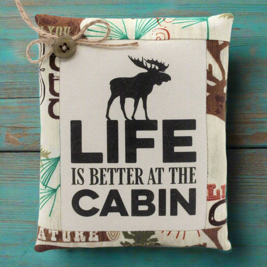 Fabric bowl filler with moose design and 'Life is Better at the Cabin' text on a wooden background