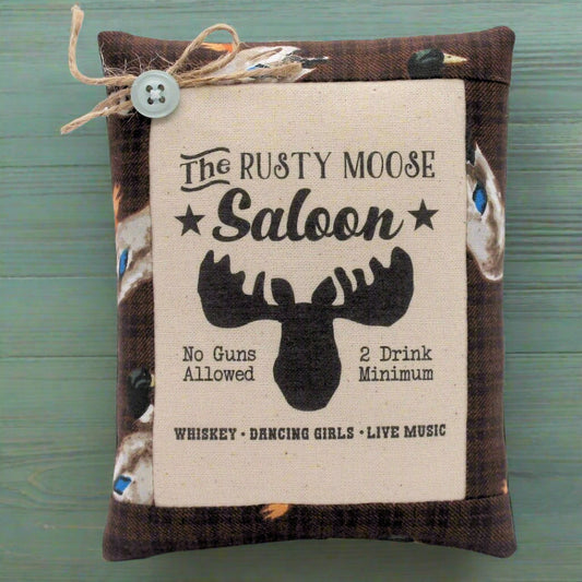 Decorative sign with 'The Rusty Moose Saloon' text and moose graphic on a wooden background.