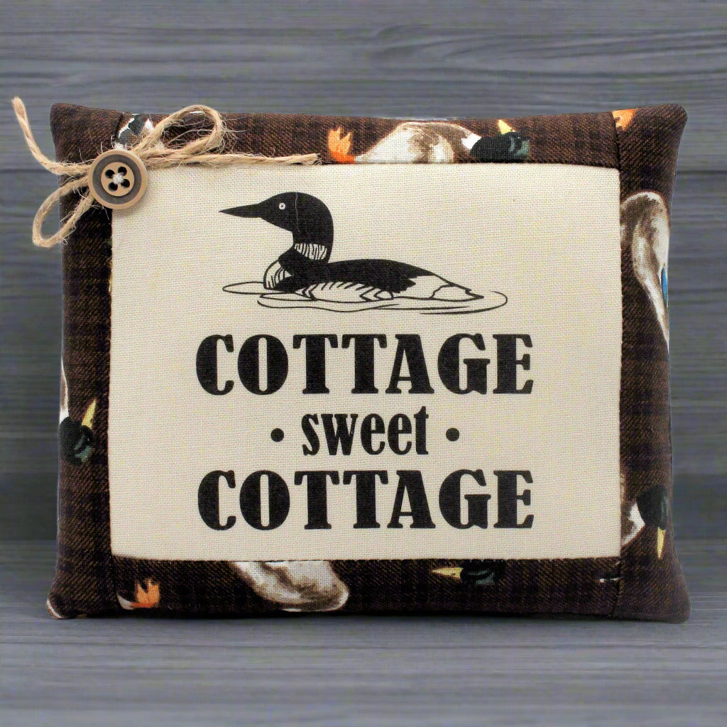 Decorative pillow bowl filler with a duck design and 'Cottage sweet Cottage' text on a wooden background
