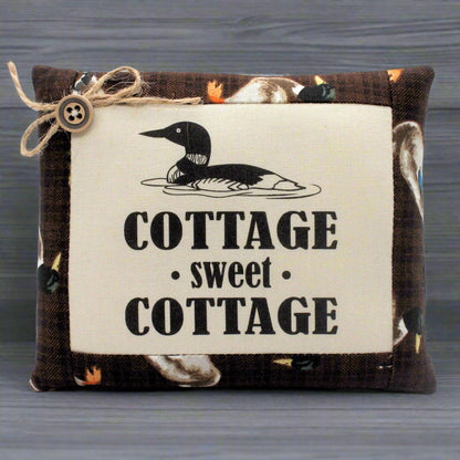 Decorative pillow bowl filler with a duck design and 'Cottage sweet Cottage' text on a wooden background