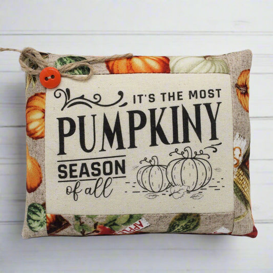 Decorative pillow with pumpkin-themed text and images on a white background