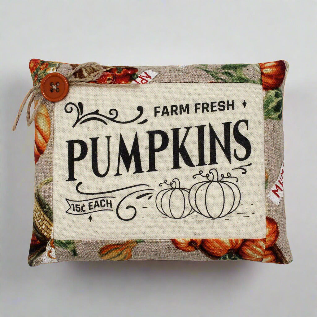 Decorative pillow with 'Farm Fresh Pumpkins' text and pumpkin pattern on a white background