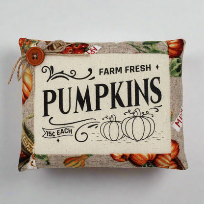 Decorative pillow with 'Farm Fresh Pumpkins' text and pumpkin pattern on a white background