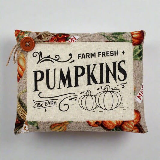 Decorative pillow with 'Farm Fresh Pumpkins' text and pumpkin pattern on a white background