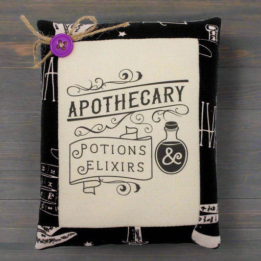 Decorative mini pillow with apothecary design and potion text on a white background