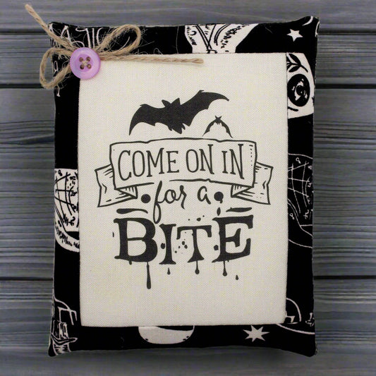 Decorative miniature pillow with Halloween-themed text and graphics on a white background