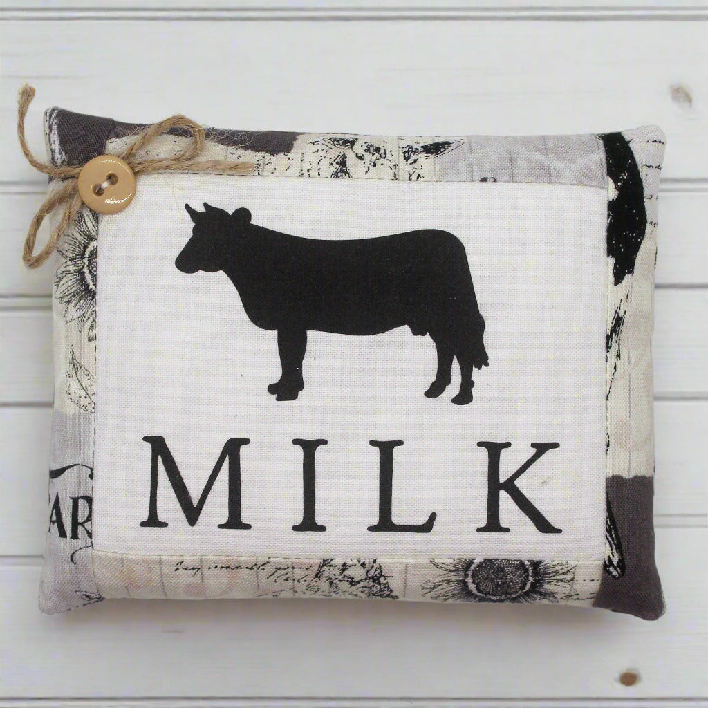 Pillow tuck with cow silhouette and 'Milk' text on a white background