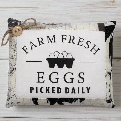 Decorative mini pillow bowl filler sign with 'Farm Fresh Eggs Picked Daily' text and egg illustration on a wooden background