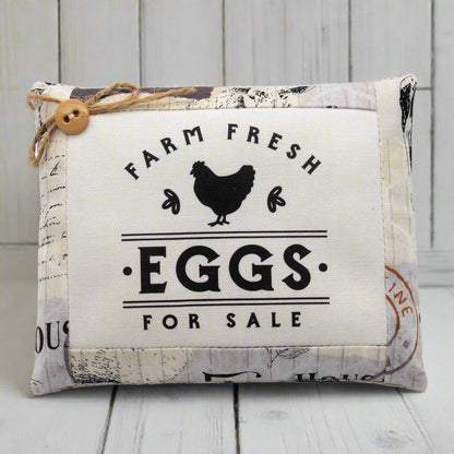 Decorative sign with 'Farm Fresh Eggs For Sale' text and a chicken illustration on a wooden background.