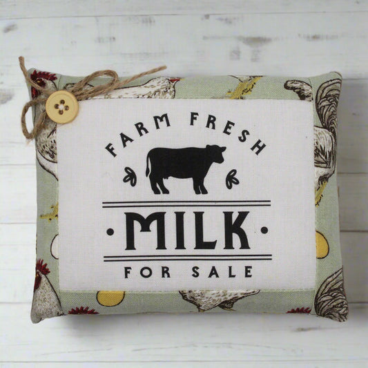 Decorative mini pillow with 'Farm Fresh Milk For Sale' text and cow illustration on a patterned background.