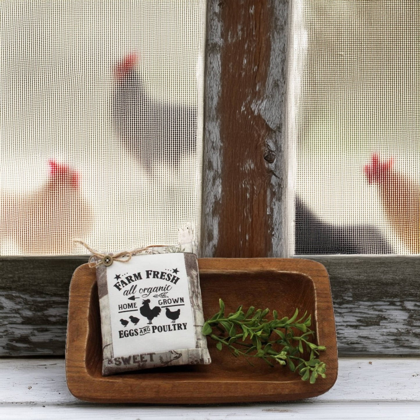 Wooden tray with a 'Farm Fresh' sign and greenery, with chickens visible through a window in the background.