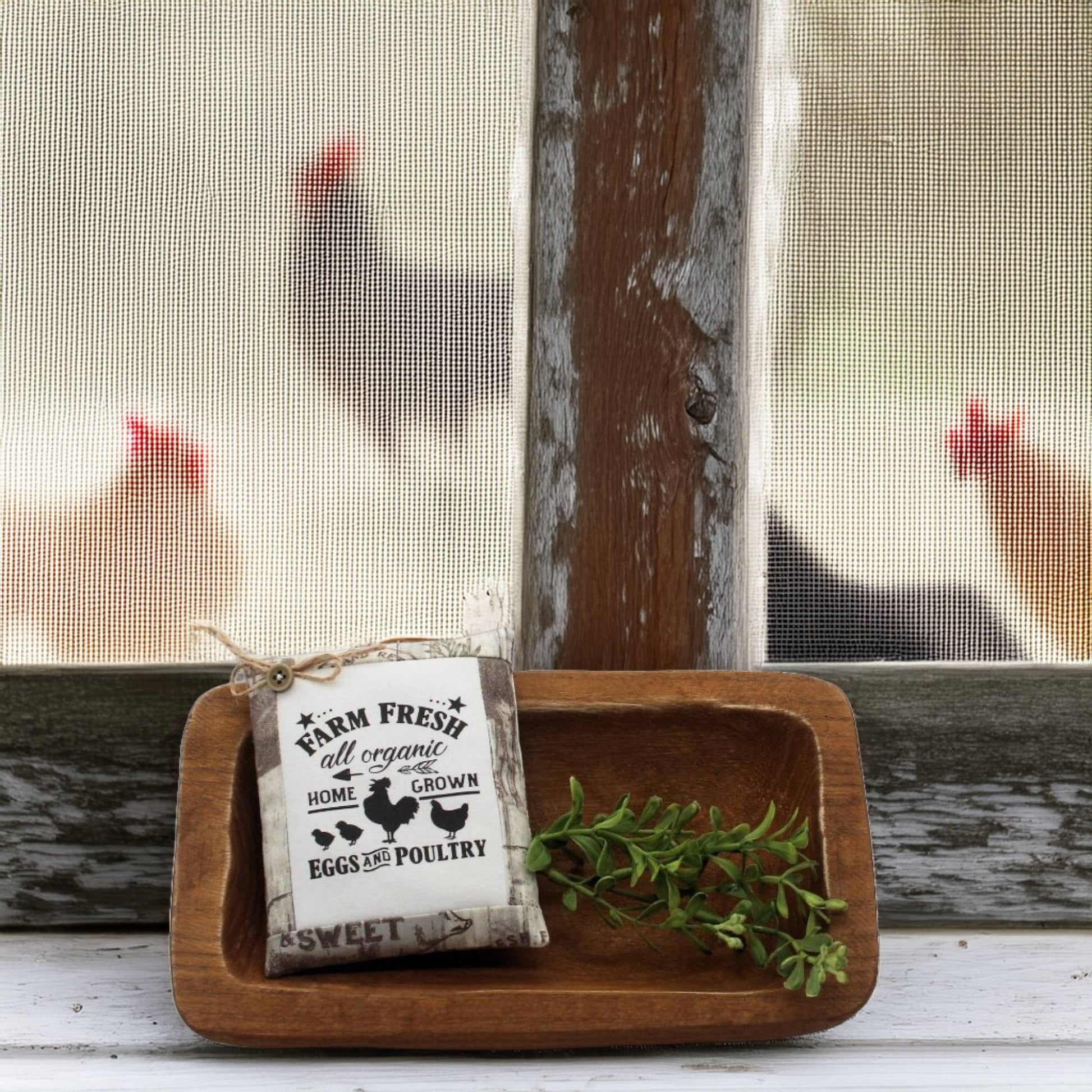 Wooden tray with a 'Farm Fresh' sign and greenery, with chickens visible through a window in the background.