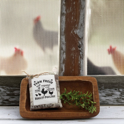 Wooden tray with a 'Farm Fresh' sign and greenery, with chickens visible through a window in the background.