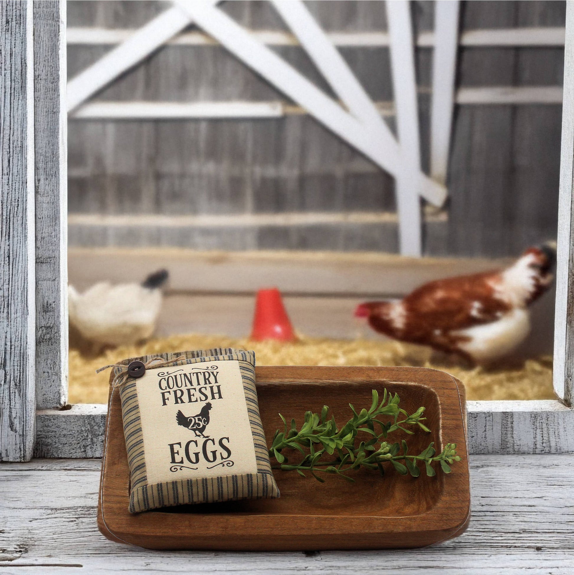 Decorative sign with 'Country Fresh Eggs' on a wooden tray with chickens in the background.