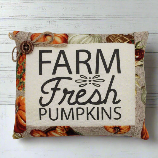 Decorative mini pillow with 'Farm Fresh Pumpkins' text and pumpkin pattern on a white background