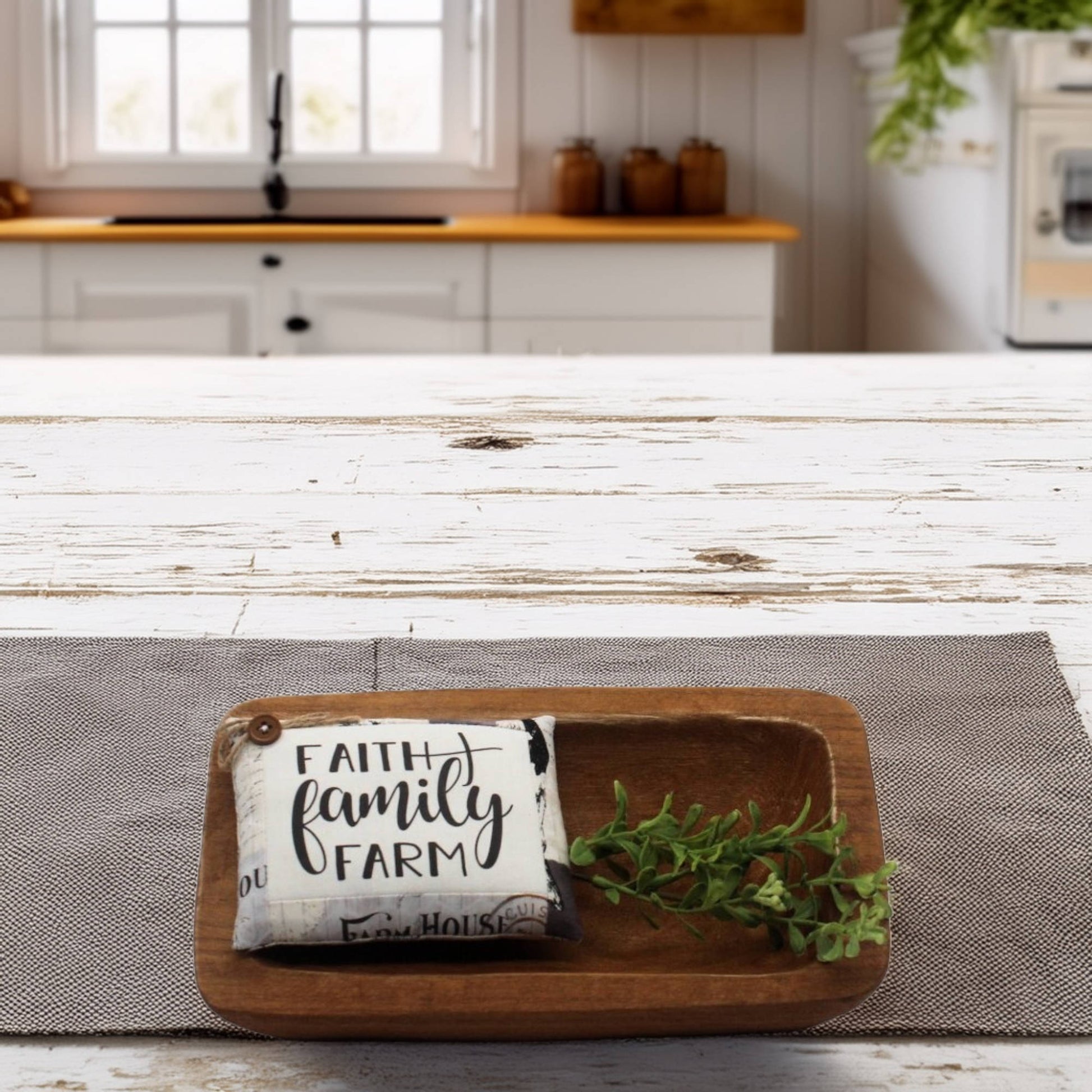 Decorative tray with a pillow and plant on a wooden table in a kitchen setting