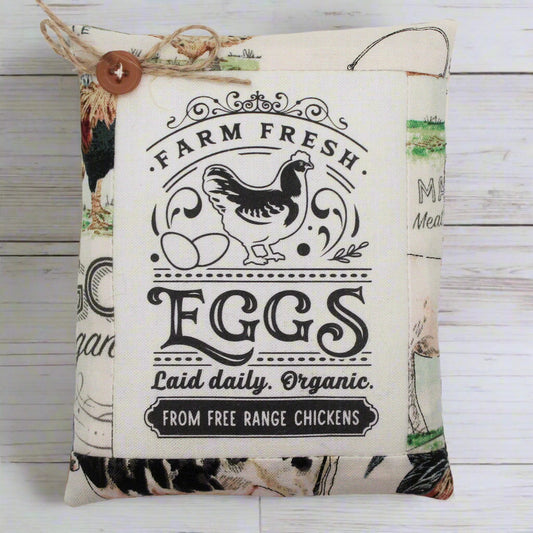 Decorative miniature pillow tuck sign with 'Farm Fresh Eggs' text and chicken illustrations on a wooden background