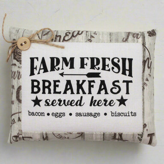 Fabric pillow tuck with 'Farm Fresh Breakfast served here' text on a white background