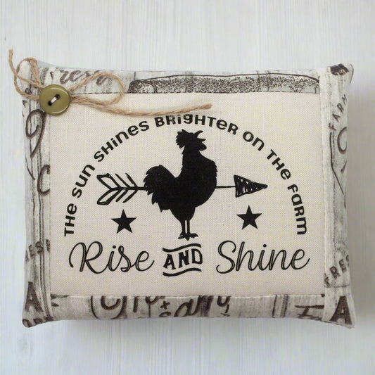 Decorative pillow tuck with rooster design and text on a white background