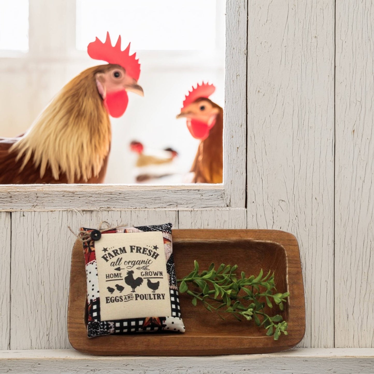 Decorative sign with chicken design on a wooden tray against a light wooden wall.