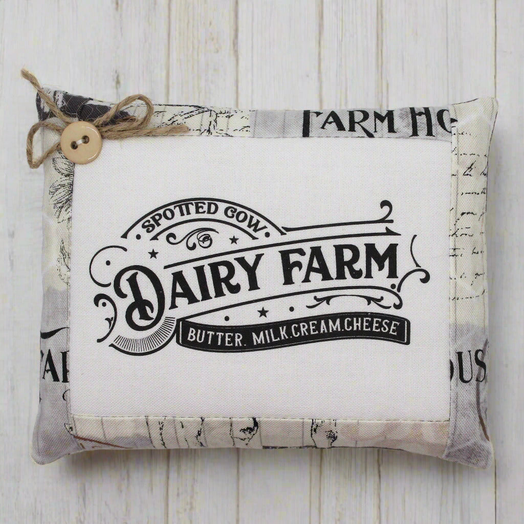 Fabric mini pillow bowl filler sign with 'Dairy Farm' text on a wooden surface