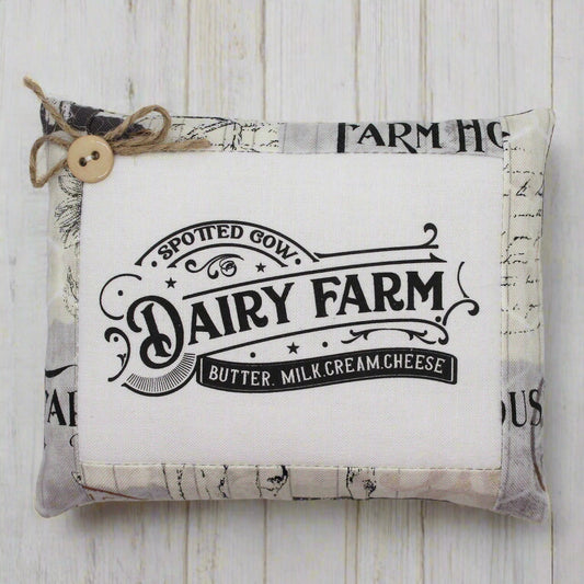 Fabric mini pillow bowl filler sign with 'Dairy Farm' text on a wooden surface
