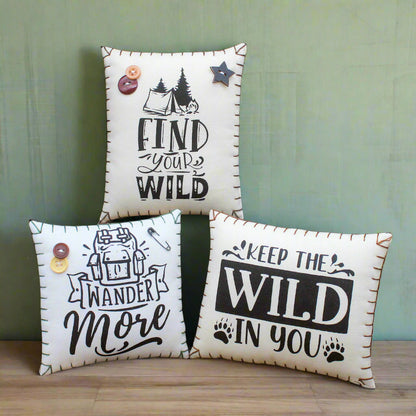 Three decorative pillows with motivational phrases on a rustic wooden background