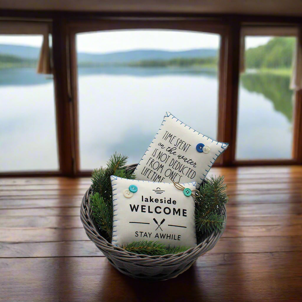 Two decorative pillows with text in a basket