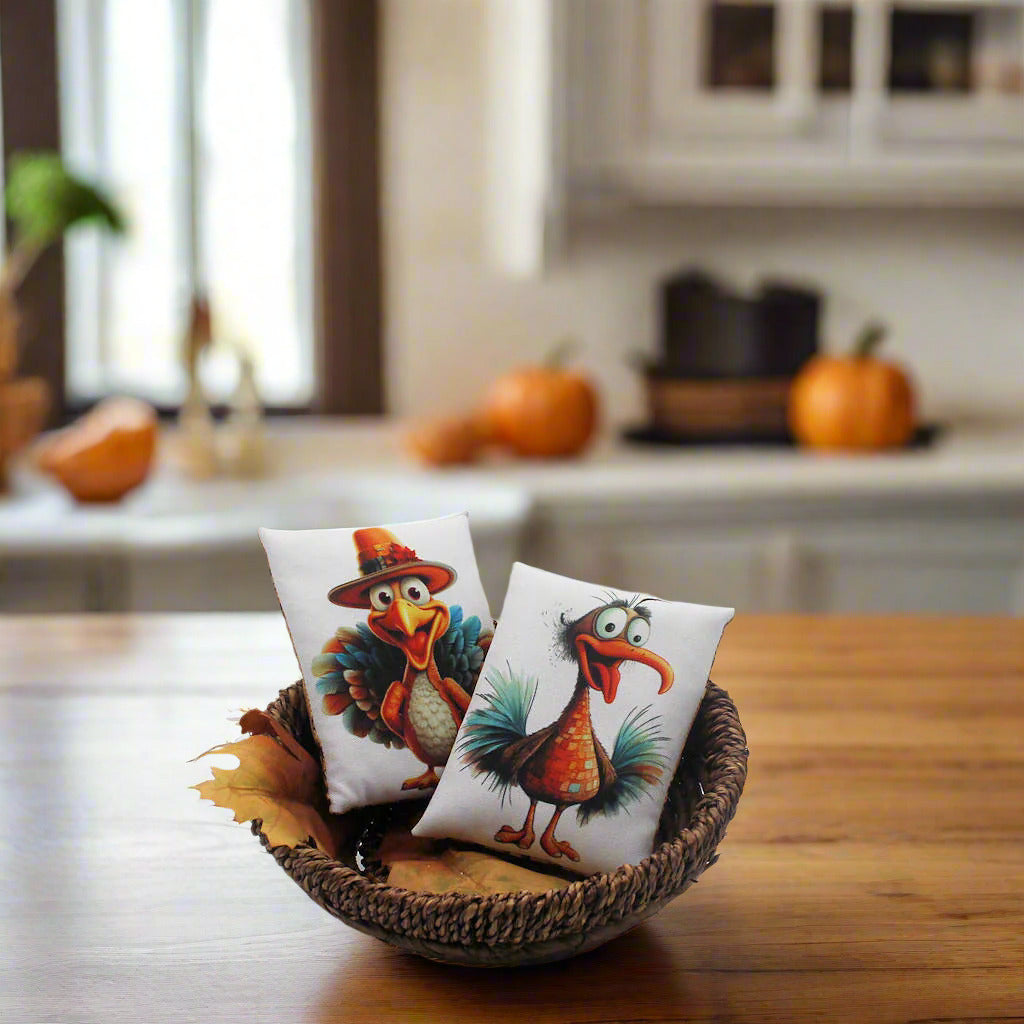 Two decorative pillows with cartoon turkeys in a wicker basket on a kitchen counter.