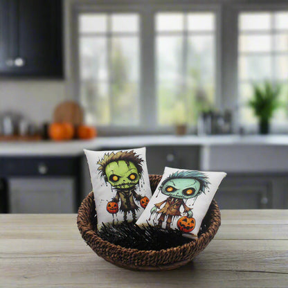 Two small pillows with cartoon zombie designs in a wicker basket