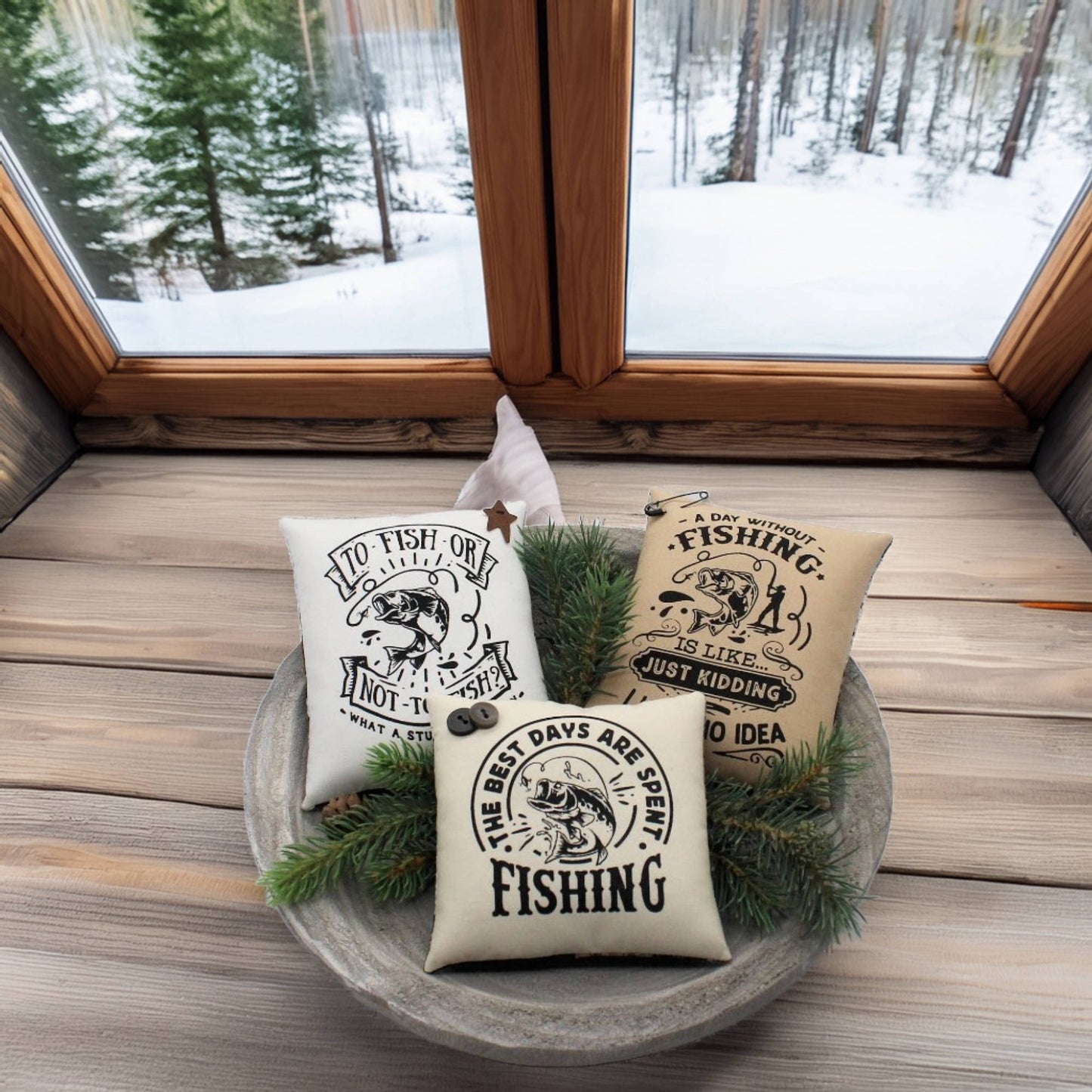 Three fishing-themed pillows in a decorative bowl with a snowy window view.