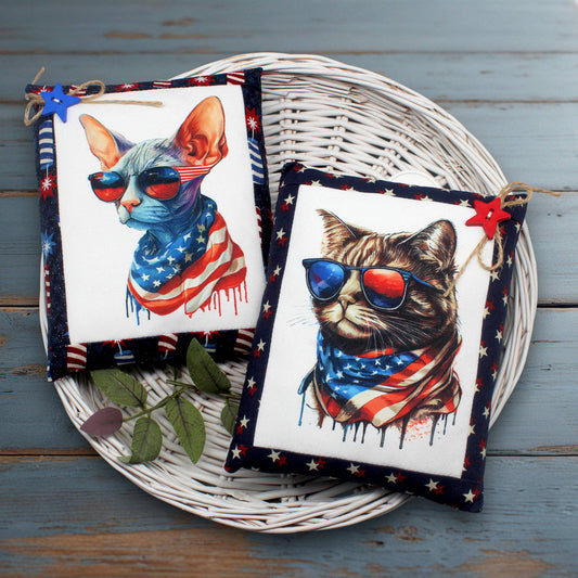 Two cat-themed mini pillow bowl fillers with American flag designs on a wicker tray.