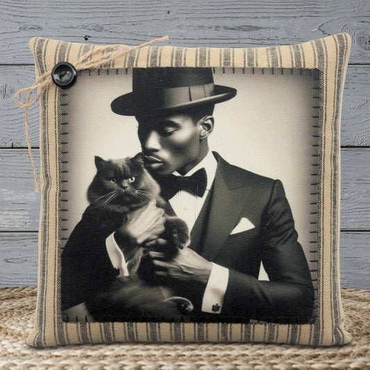 Pillow with a black and white photo of a man in a suit holding a cat, framed by striped fabric.
