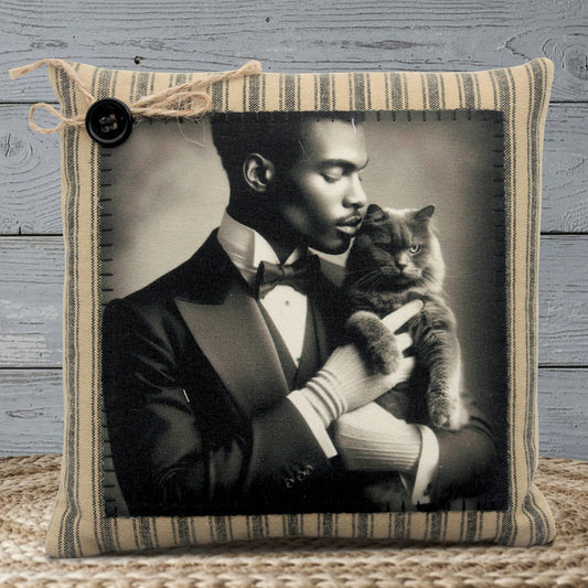 Pillow with a vintage-style photo of a man in a suit holding a cat, framed in a striped fabric border.