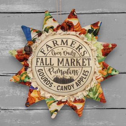 Primitive handmade fabric sunflower ornament with a printed center that advertises for a fall farmers market