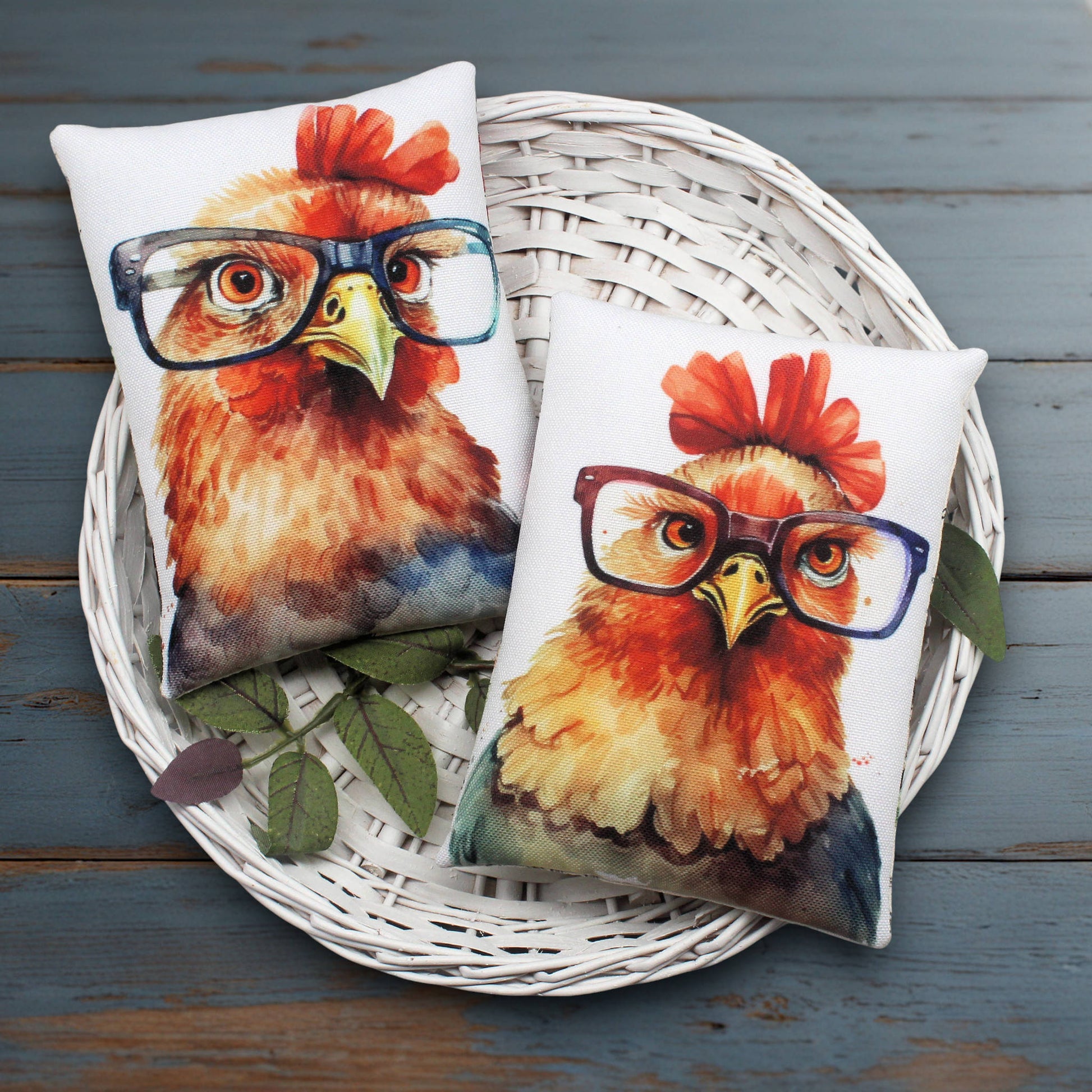 Two pillows with rooster designs wearing glasses on a white basket.