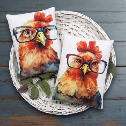 Two pillows with rooster designs wearing glasses on a white basket.