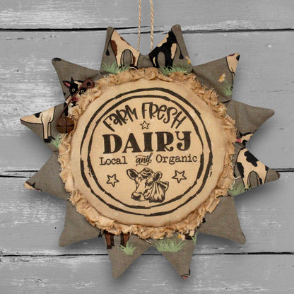 Handmade primitive sunflower ornament with a printed center that advertises for a dairy farm