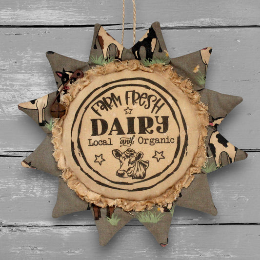 Handmade primitive sunflower ornament with a printed center that advertises for a dairy farm
