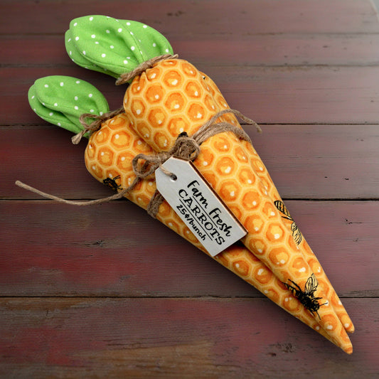 Plush carrot bundle with a tag on a wooden surface