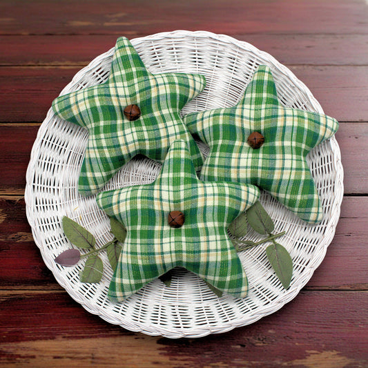 Green plaid star-shaped decorative items on a white woven basket against a wooden background